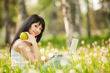 Canvas Print - Cute woman with white laptop in the park with dandelions