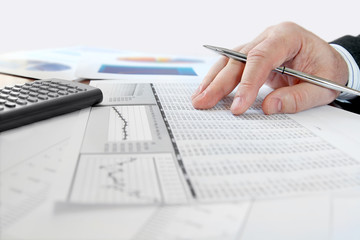 Fototapete - Male hand with pen analyzing  financial data