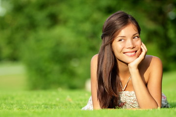 Wall Mural - Asian woman lying in grass