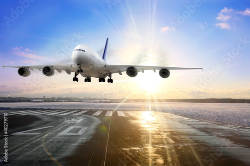 Cuadros en Lienzo Passenger airplane landing on runway in airport. Evening
