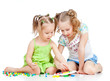 elder sister training young one to collect mosaic toy over white