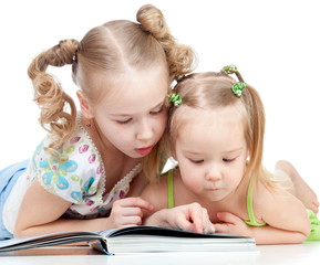 two sisters reading a book together