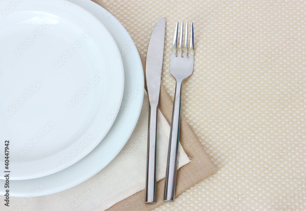 Table setting with fork, knife, plates, and napkin