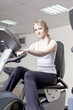 © Shchipkova Elena - girl in a sports hall on a velosimulator