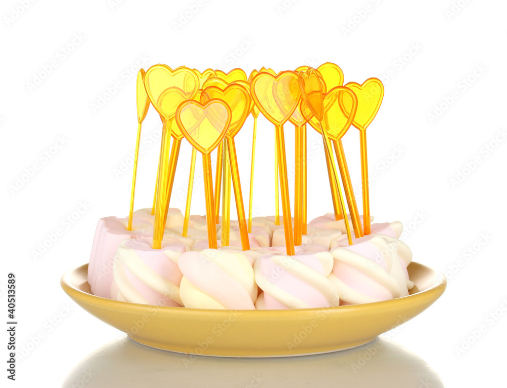 Marshmallows with skewers on plate isolated on white