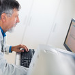 © lightpoet - Senior researcher working on a computer in a lab