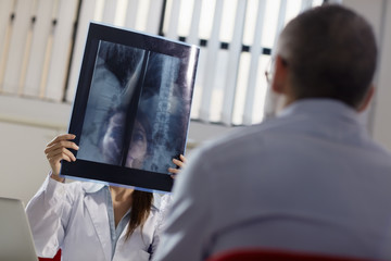 Female doctor working in hospital with patient and x-rays