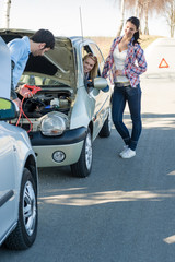 Starter cables man helping two women