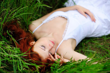 Girl portrait, lying in grass field.