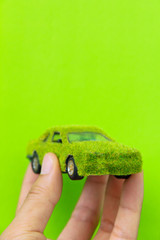 Fototapete - Hand Holding Eco car icon isolate on green background
