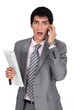 businessman talking on his cell and looking surprised