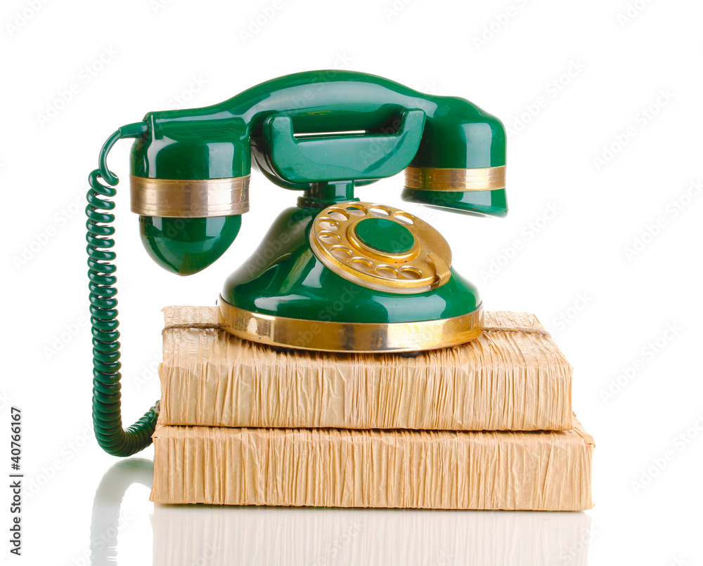Retro phone standing on books isolated on white