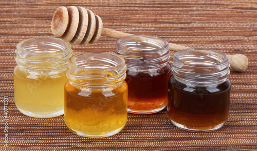 Fototapeta na wymiar jars full of honey wooden stick, mix taste