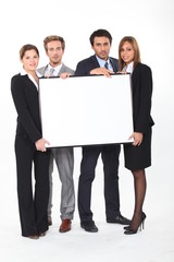 executives holding a framed board left blank for your image