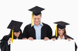 © WavebreakmediaMicro - Three students having graduated holding blank sheet and looking