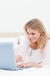 © WavebreakmediaMicro - Close up, Woman using a laptop while on the bed and smiling