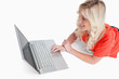 © WavebreakmediaMicro - Smiling woman lying down while looking at her laptop