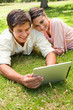 © WavebreakmediaMicro - Woman leans against her friend as they use a tablet together