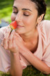 © WavebreakmediaMicro - Woman smells an strawberry while lying in grass