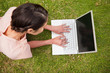 © WavebreakmediaMicro - Elevated view of a woman using a laptop while lying down