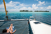 Young Woman Sunbathing On The Catamaran
