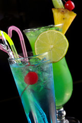 Wall Mural - green cocktail with pineapple and blue cocktail with ice and lim