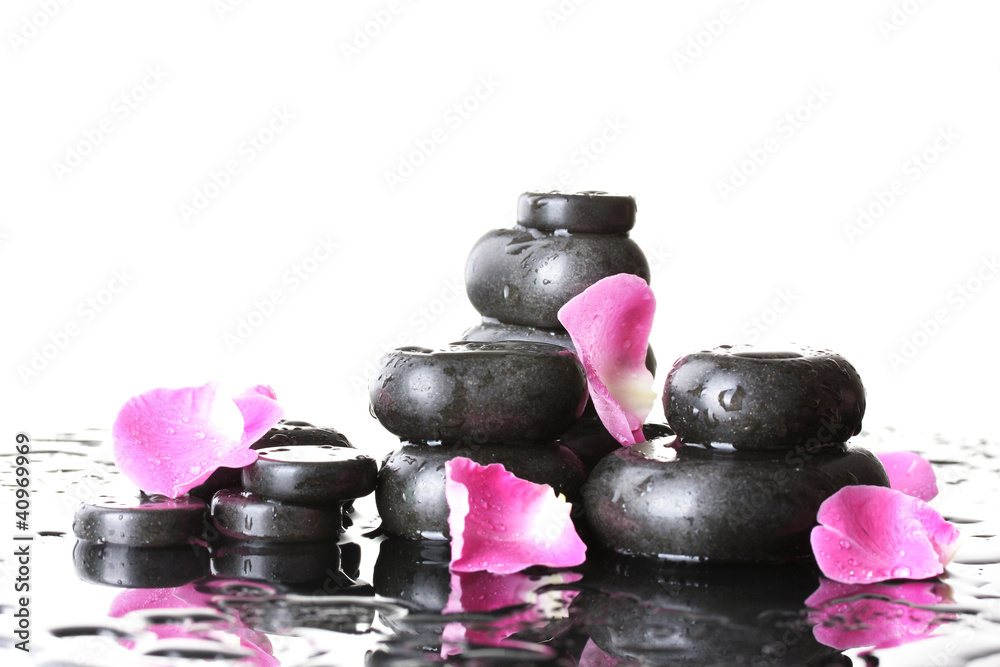 Spa stones with drops and rose petals on white background