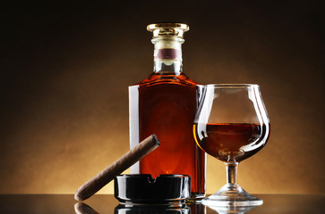 Wall Mural - bottle and glass of brandy and cigar on brown background