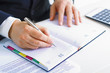 © nenetus - Business man in dark suit writing on his datebook