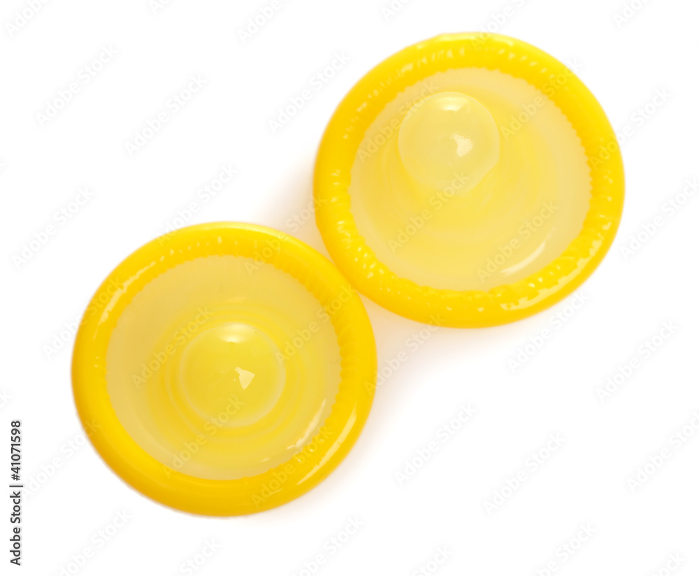 Two yellow condoms isolated on white