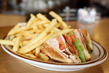 Delicious club sandwich with french fries at a diner.