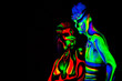 © orelphoto - Man and woman with fluorescent bodyart. Black background. Studio