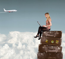 Beautiful Blond Girl Sitting On Suitcases Above Clouds