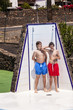 © travelview - boys have fun unter the pool shower