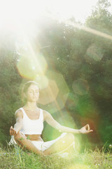 Wall Mural - Young woman doing yoga exercise in green park