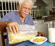 © Gustavo Andrade - Abuelo desayunando cereal en casa.