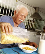 © Gustavo Andrade - Abuelo desayunando cereal en casa.