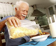 © Gustavo Andrade - Abuelo desayunando cereal en casa.