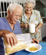 © Gustavo Andrade - Abuelos en la cocina comiendo cereal.