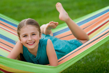 Wall Mural - Lovely girl playing in colorful hammock