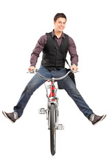 Canvas Print - Studio shot of a young happy man riding a bike