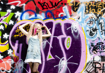 Wall Mural - young woman standing at graffitti wall