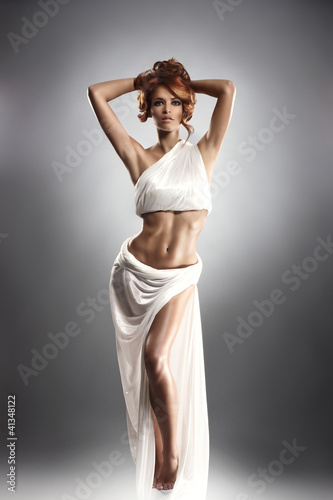 Fototapeta na wymiar Fashion shoot of a young redhead woman in a beautiful dress