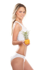 Wall Mural - A young and sexy blond woman holding a fresh fruits