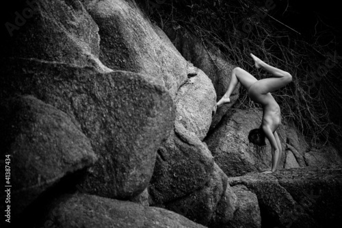 a beautiful young girl standing on his hands on the stones - 41387434