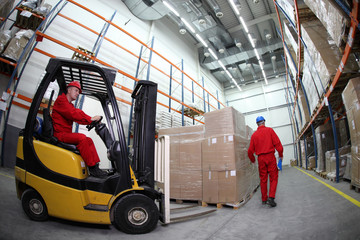 two workers work in storehouse