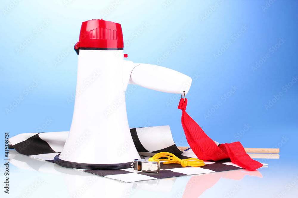 Checkered finish flag and megaphone on blue background
