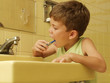 © Gustavo Andrade - Niño cepillándose los dientes en un baño.