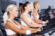 © michaeljung - group of young women cycling in gym