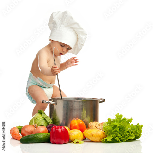 Nowoczesny obraz na płótnie Little boy in chef's hat with ladle, casserole, and vegetables